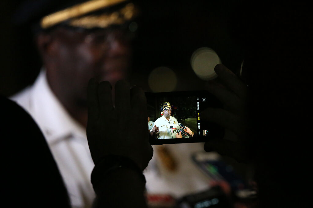 A reporter takes a photo of St. Louis Police Chief John Hayden with an iPhone early Tuesday morning